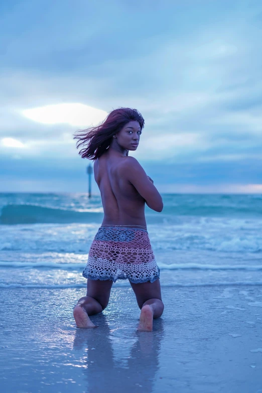 a little girl is walking on the beach