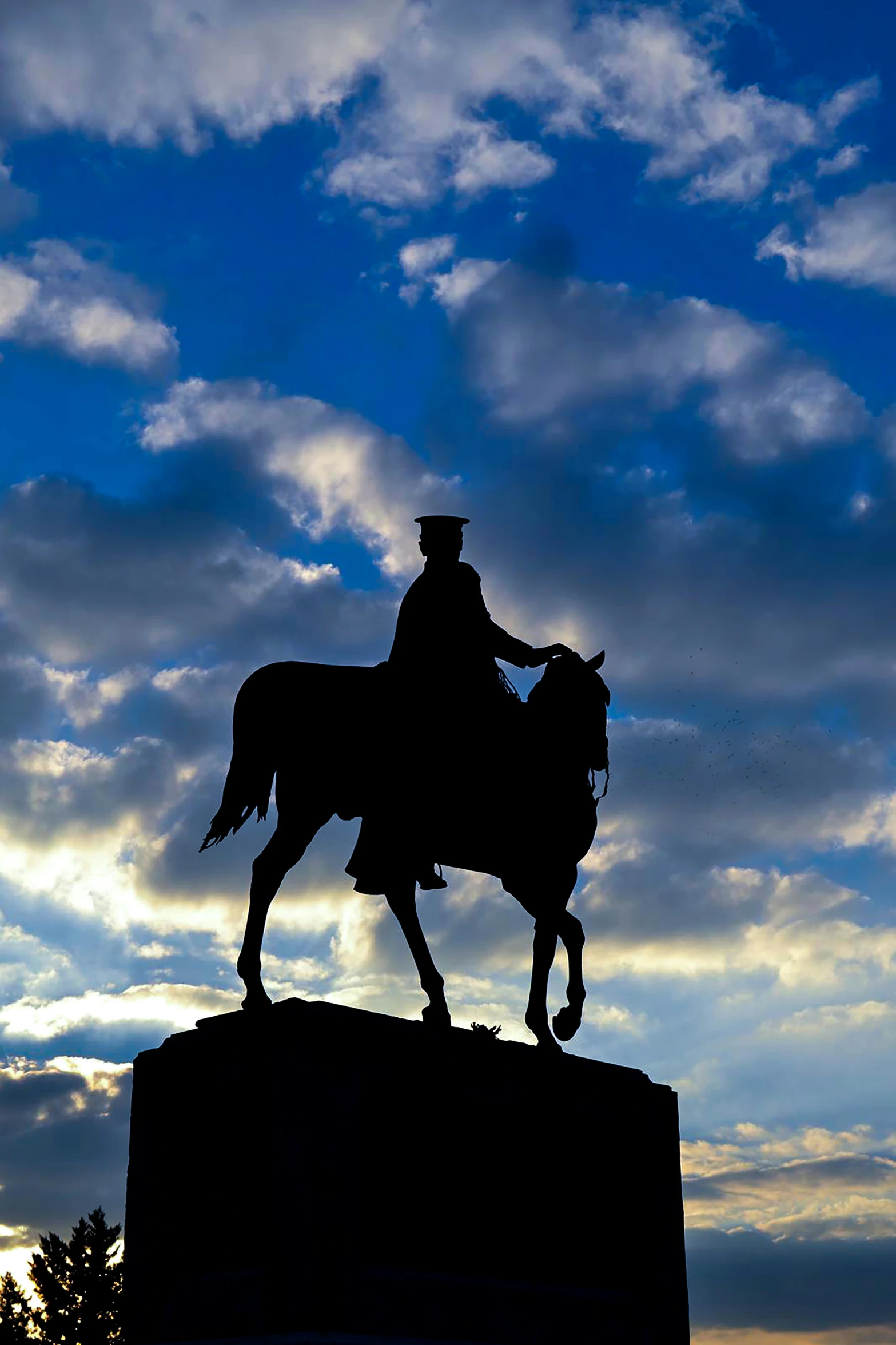 a silhouetted man riding on the back of a horse