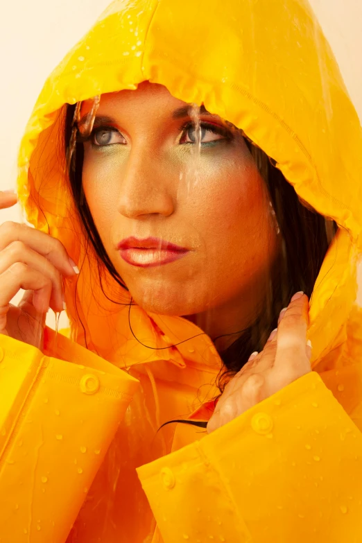 a woman in yellow rain jacket posing with a handbag on her hip