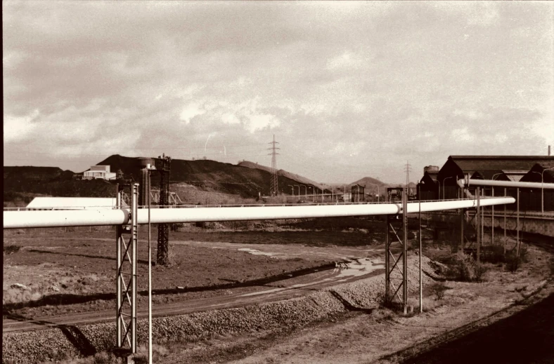 an old airplane is on a road near a train yard