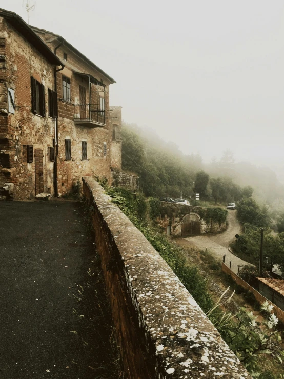 the old house on the hill is standing on a mountain side