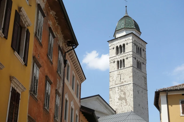 a clock tower is seen from behind two buildings