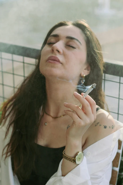 a woman smoking a cigarette outside in the rain