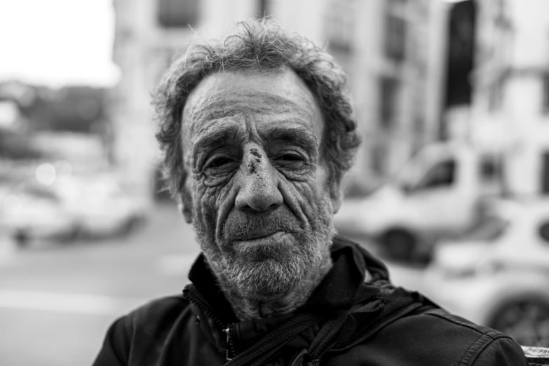 an elderly man standing in the street in front of a city traffic