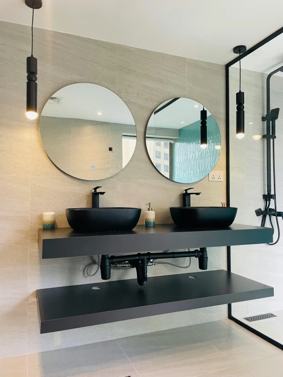 a couple of sinks in a bathroom with mirrors above them