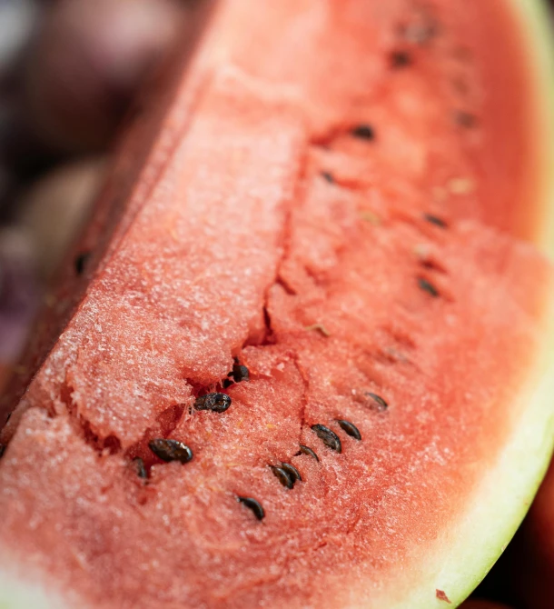 a close up of a piece of watermelon in a bunch of fruit