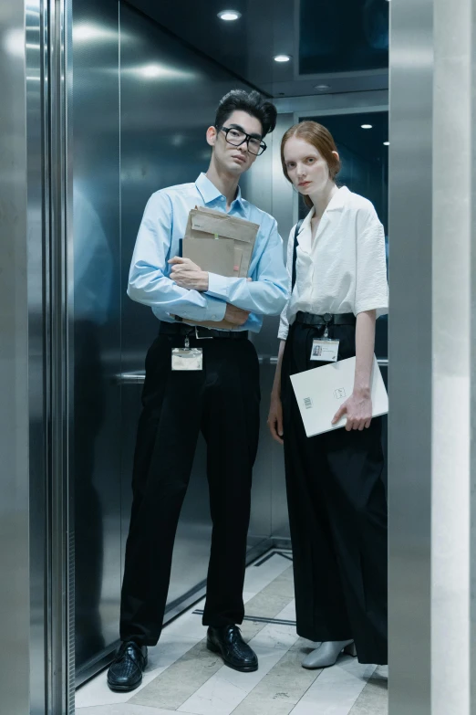 a man and woman standing inside an elevator