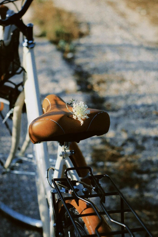 the bicycle is parked on the pavement with the bike seat still attached