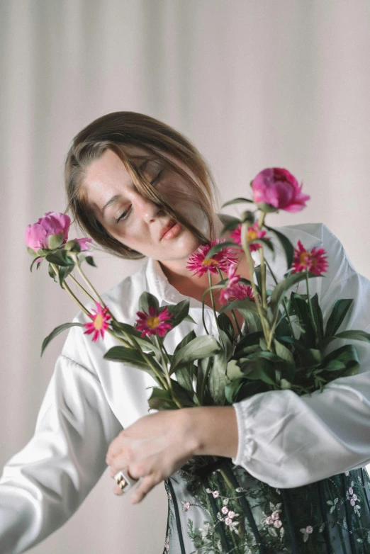 a woman that is holding a bunch of flowers