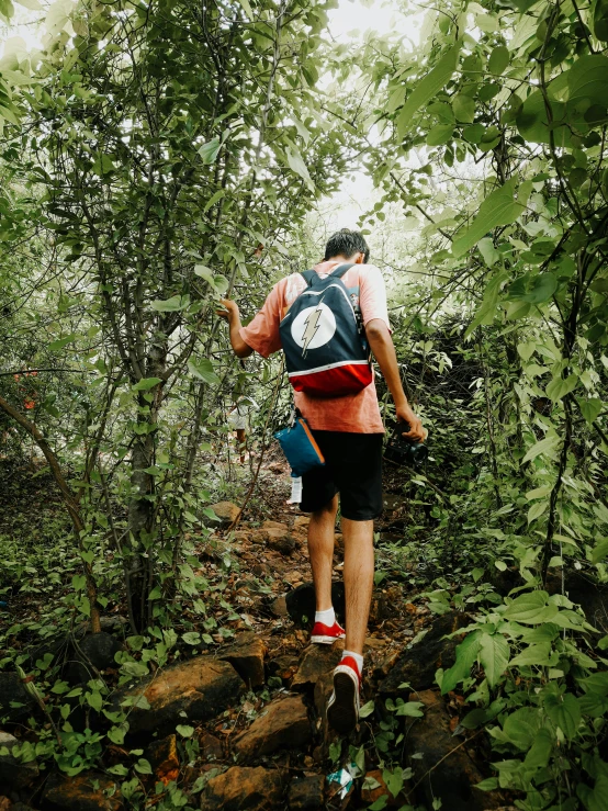 a man walking through the woods carrying soing