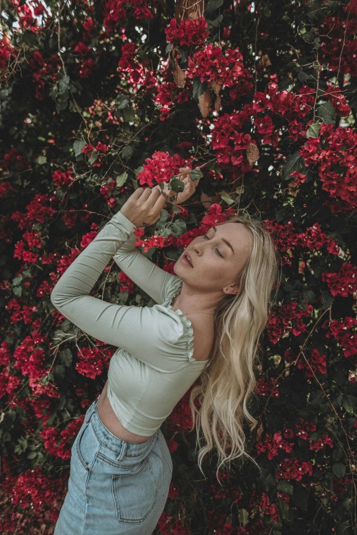 a blonde woman in grey shirt and ripped jeans