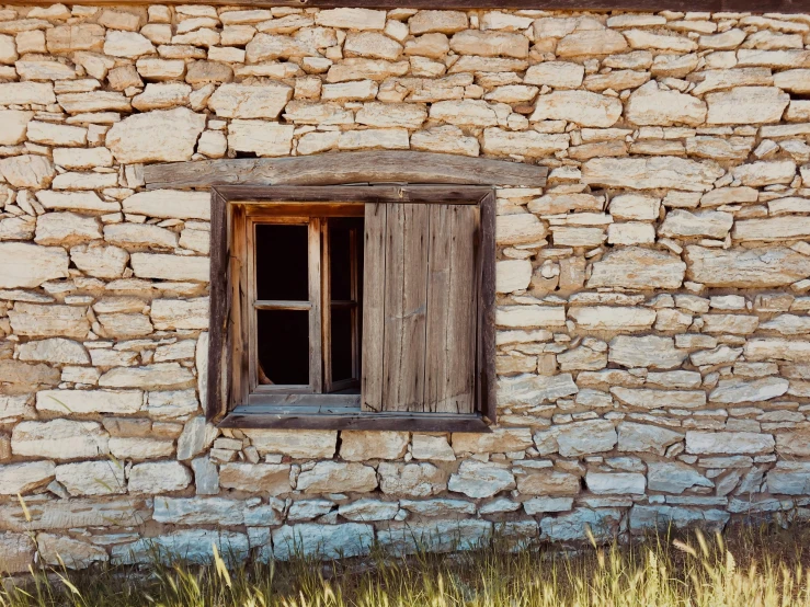 an old stone house with wooden door and window