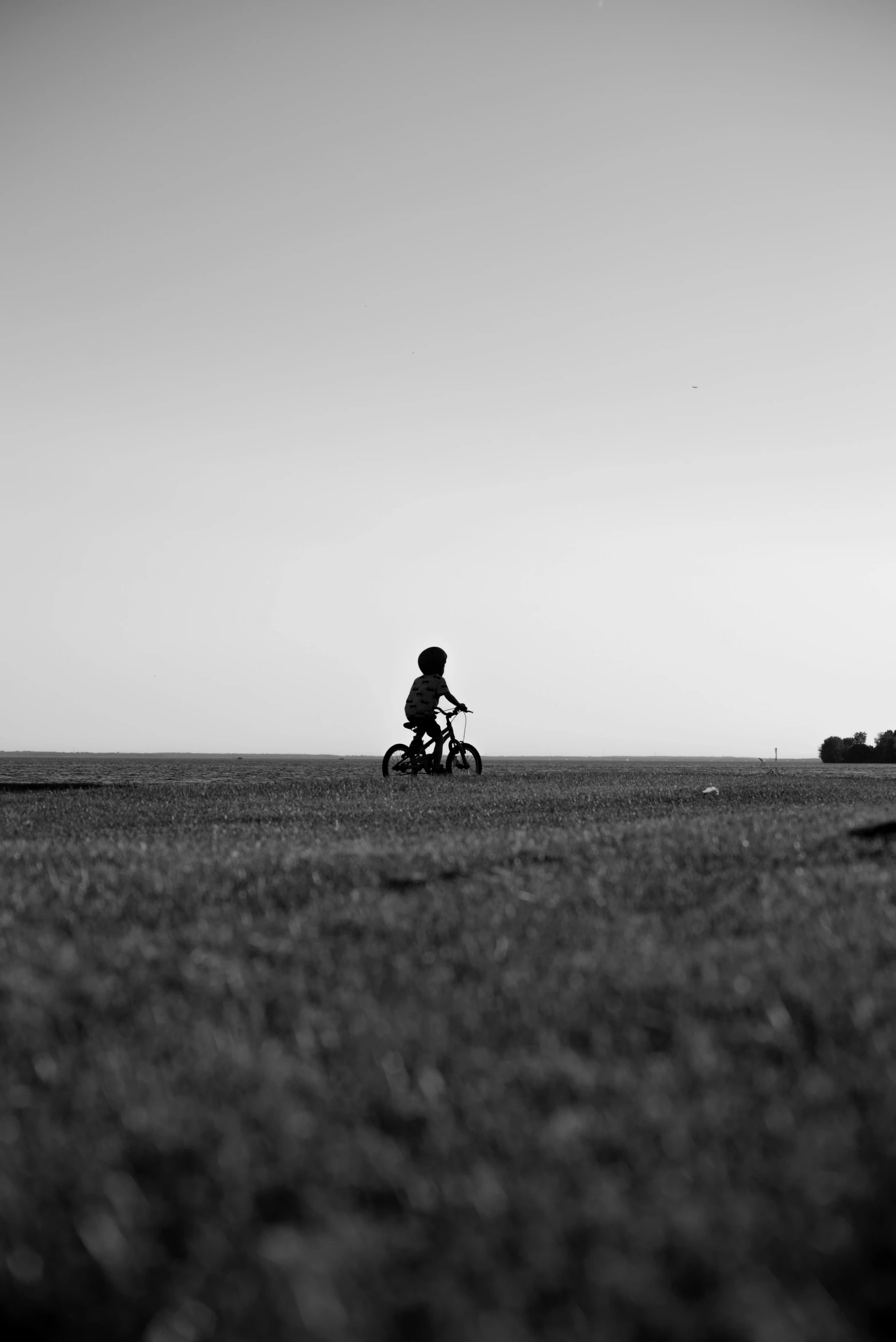 a child rides a bike across the wide open space