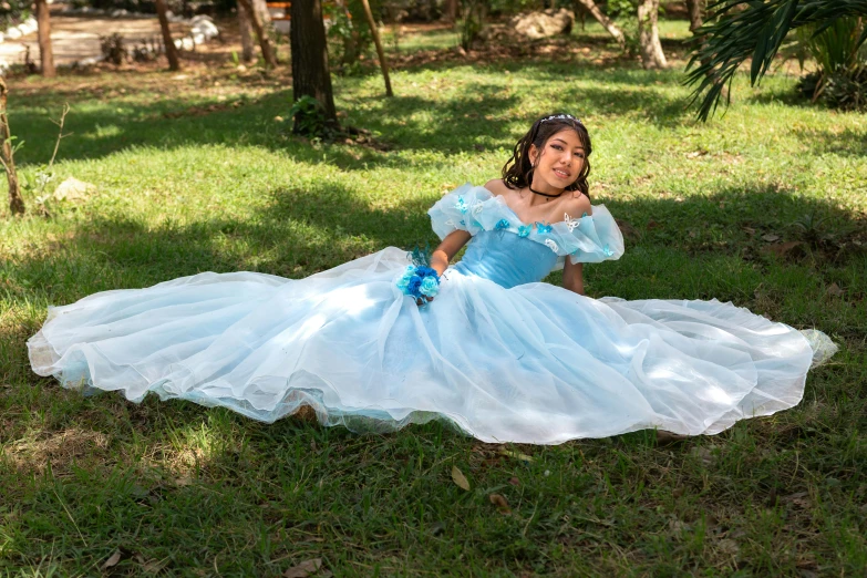 a woman dressed as princess sitting on grass