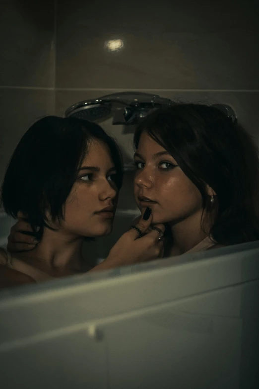 two women sitting in a bathtub with their backs to each other