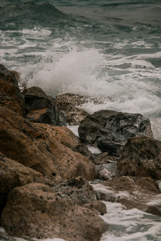 an umbrella sitting on the edge of a rock next to the ocean