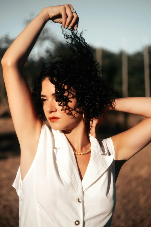 the woman with curly hair is wearing a white shirt