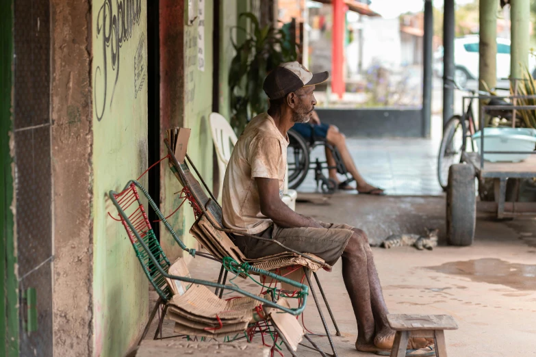 a man sitting on a chair outside of a shop