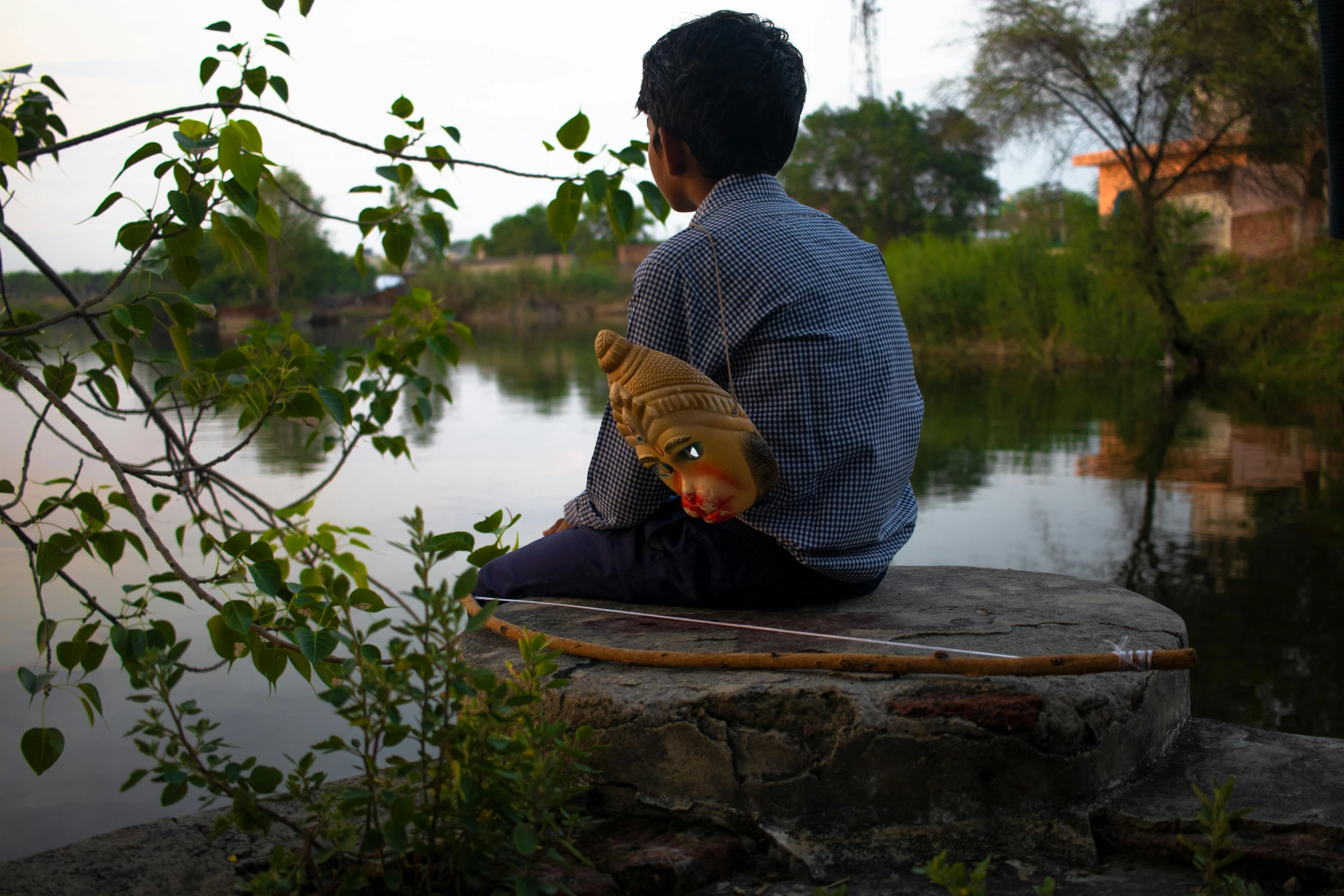 a man is sitting down and holding a stuffed fish