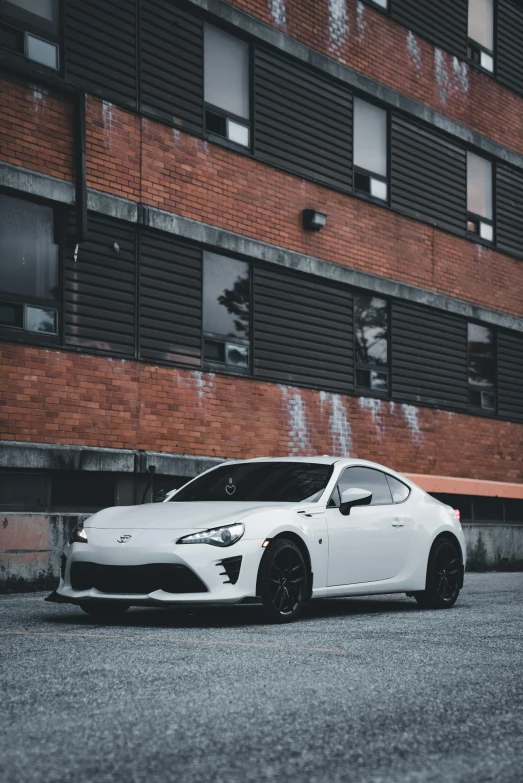 a white car parked next to a tall building