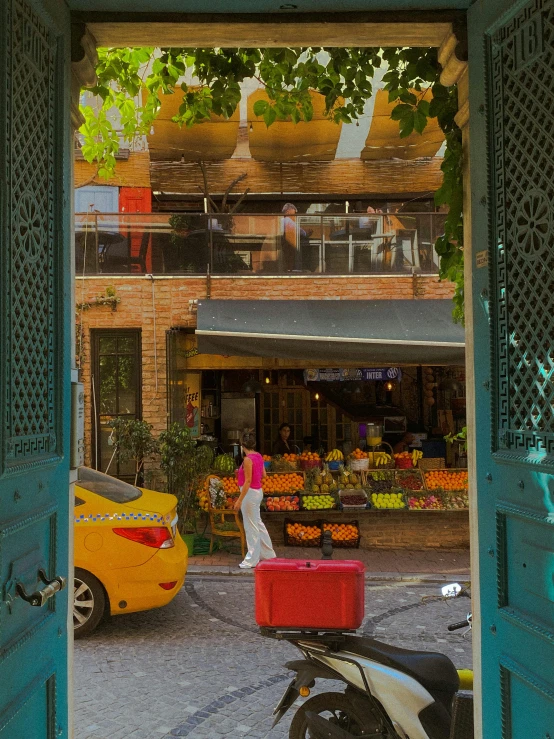 a woman walking into the open door of an outdoor market