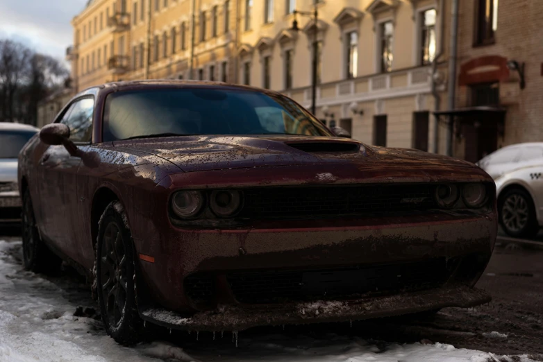 a rusty looking car in the middle of the road