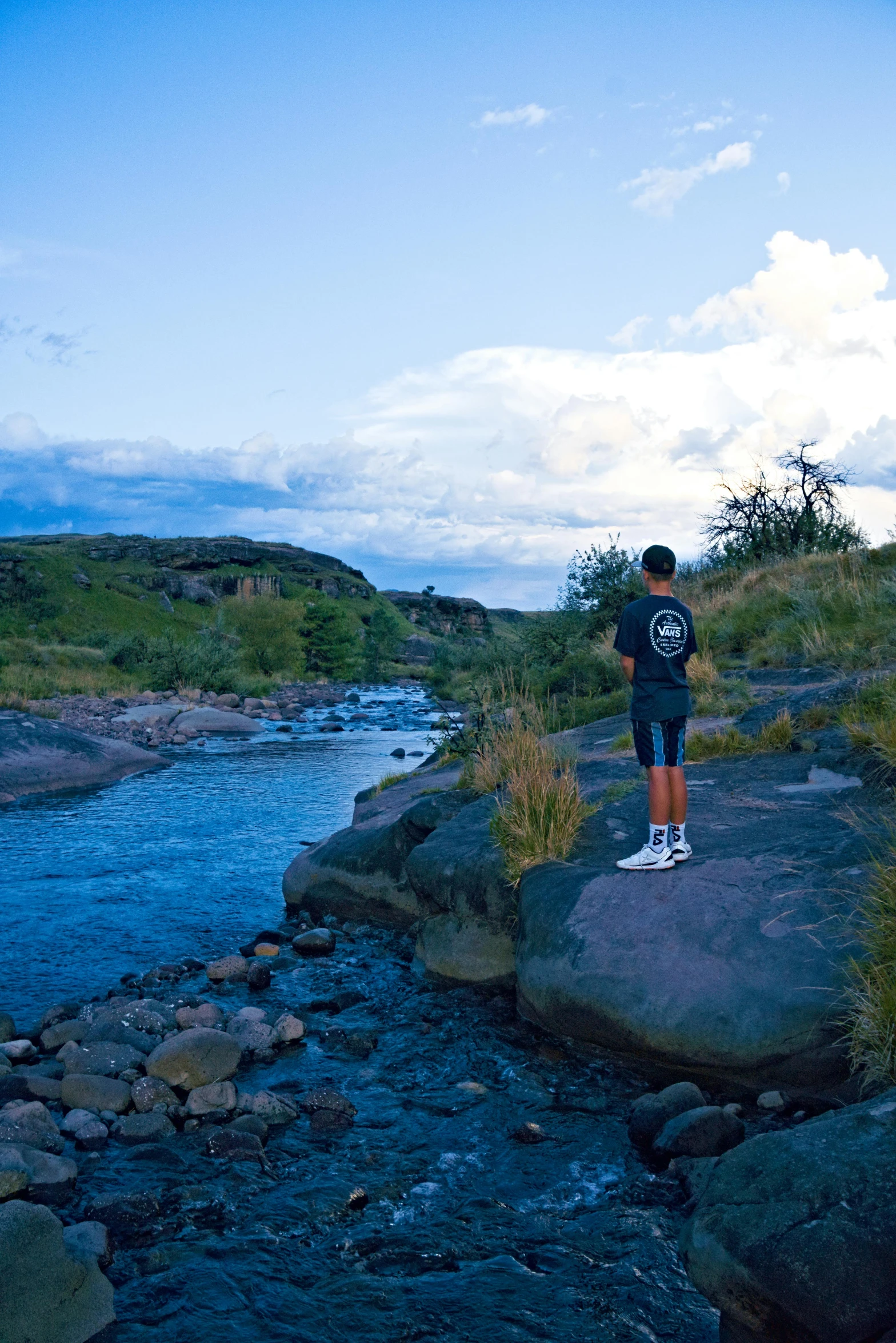 a person standing on a rocky cliff by the water