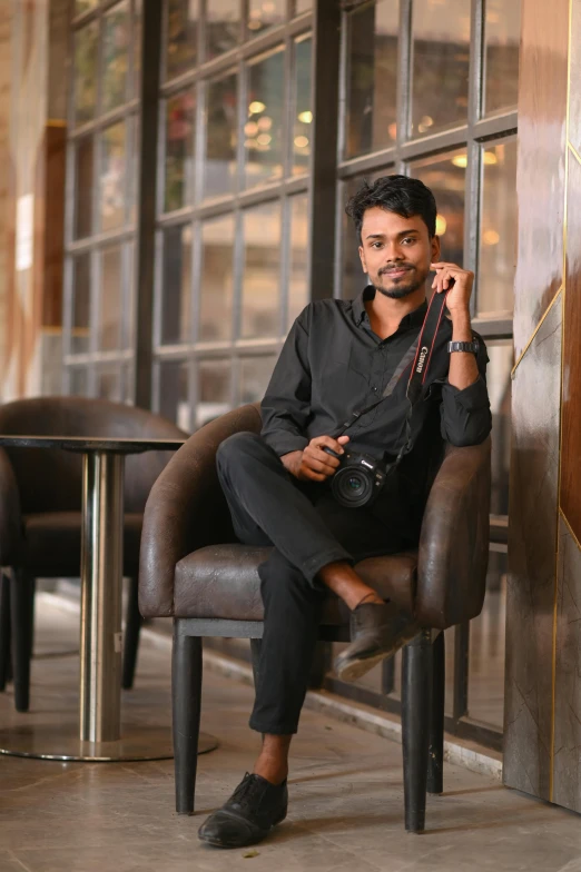 a man sitting in a chair posing for a po