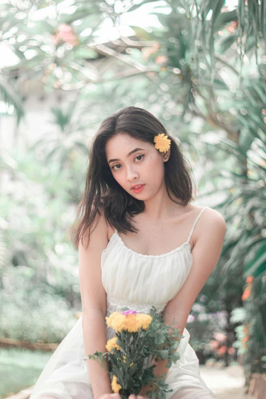 the woman is holding a flower bouquet posing for a po