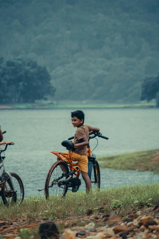 there are two children on the grassy area with bikes