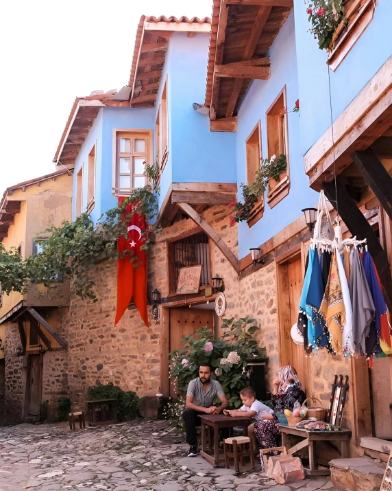 a group of people sitting in a courtyard near buildings