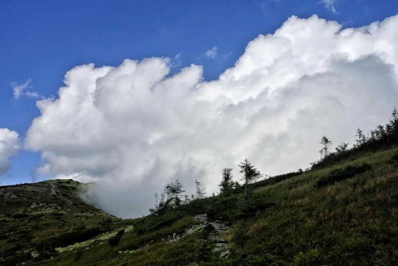 clouds are over the mountains on a sunny day