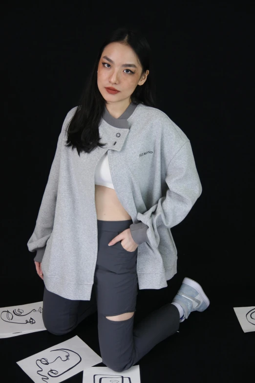 a girl wearing a gray cardigan and black leggings poses for a picture