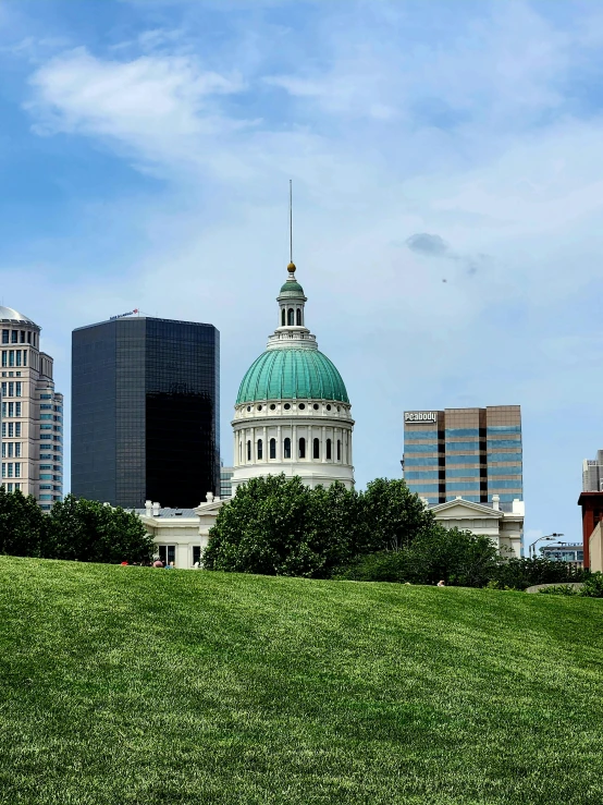 the building is sitting behind tall buildings that are also part of the city skyline