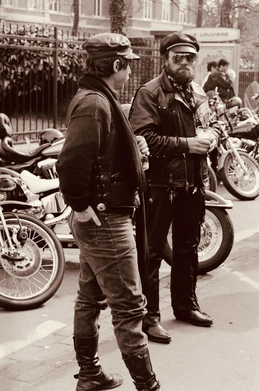 two guys in jackets are standing on the side of the road talking