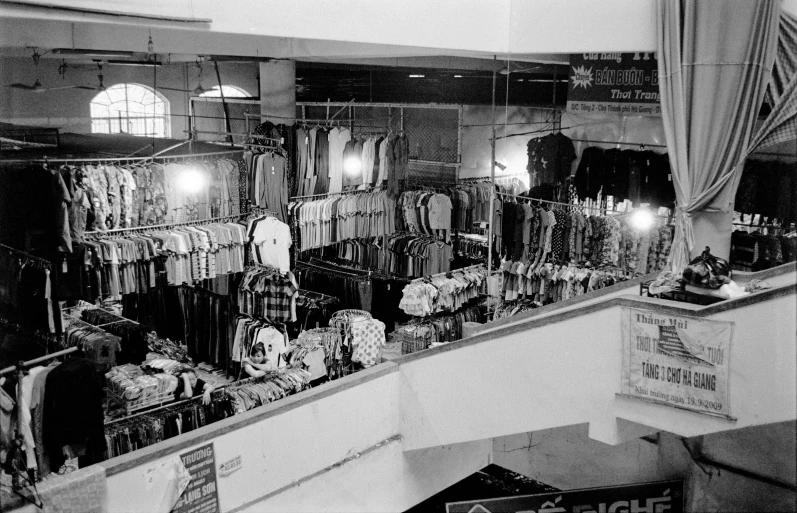 a room with shirts hanging on the rack and other clothes behind the railing