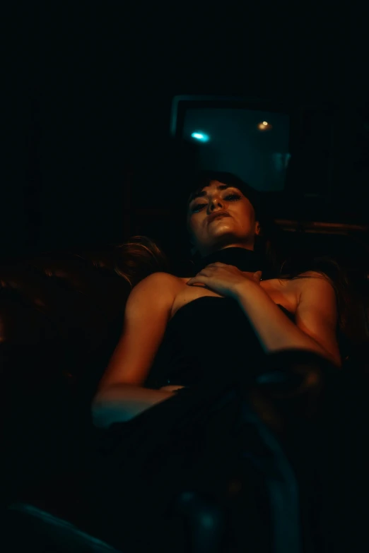 a young lady laying on a couch under a lit light