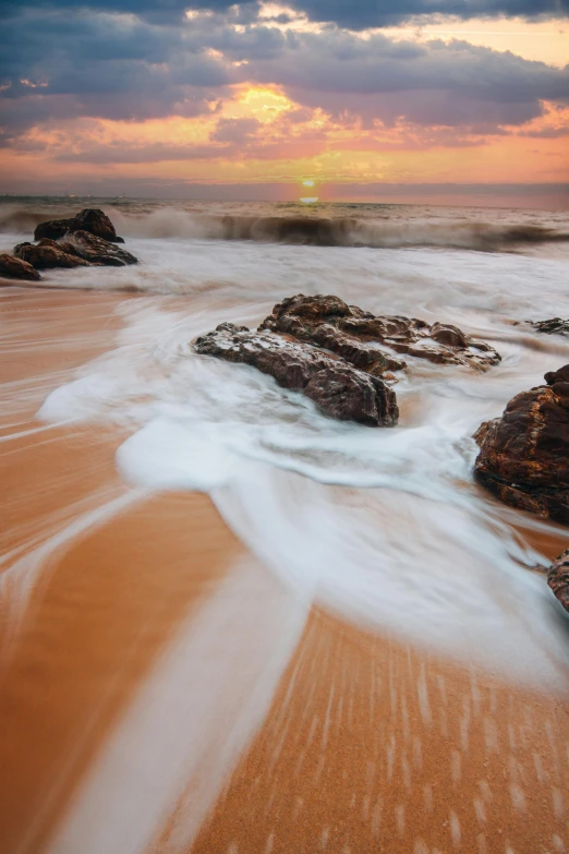 a beautiful sunset shines brightly behind some very pretty waves