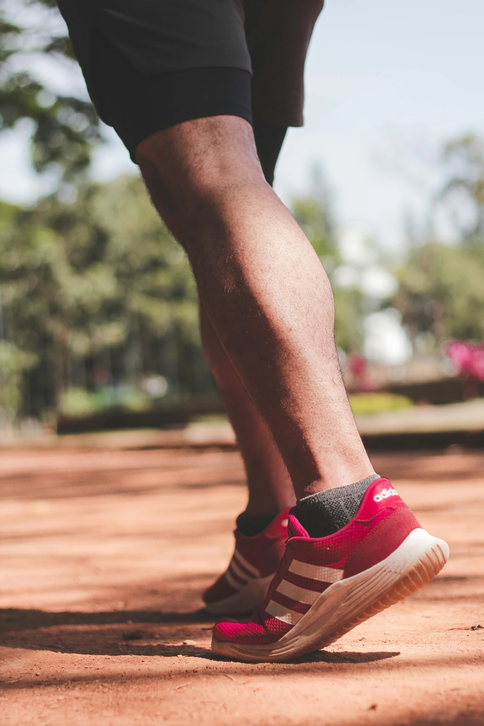 a close up of a person's feet with red sneakers