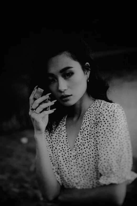 woman sitting on chair holding cigarette and looking down