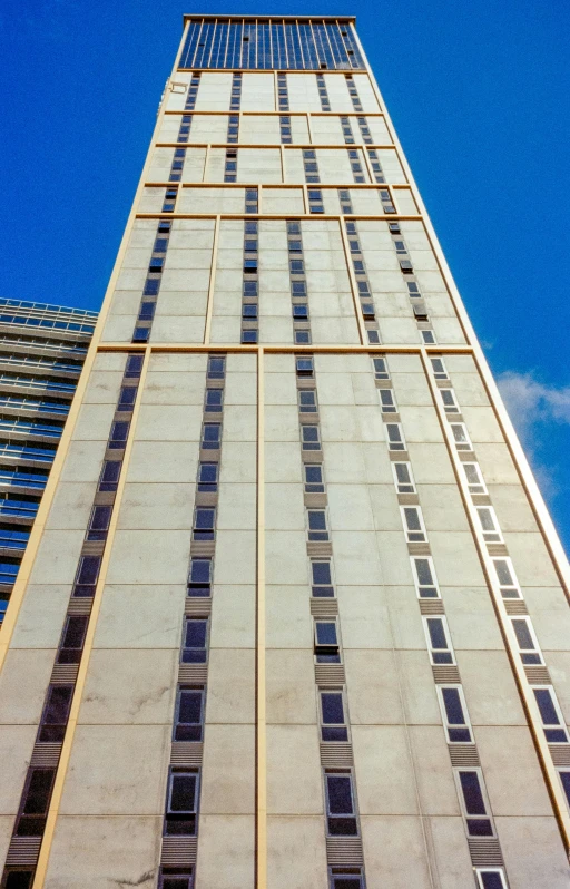 a tall building with glass windows and a sky background