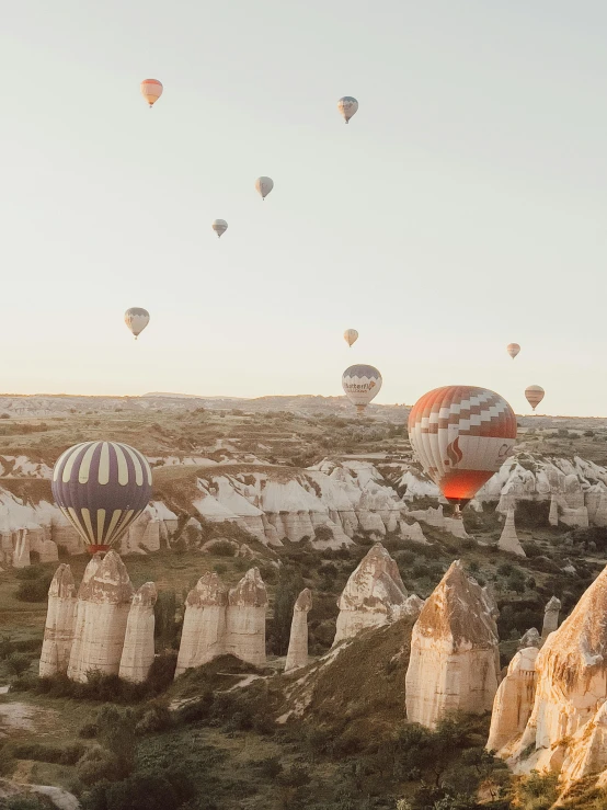 a group of  air balloons flying over a field