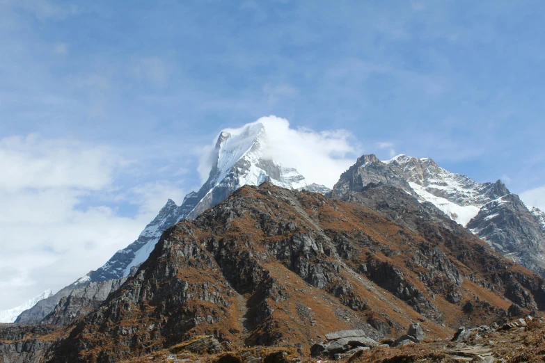 a mountain has a cloud covered peak