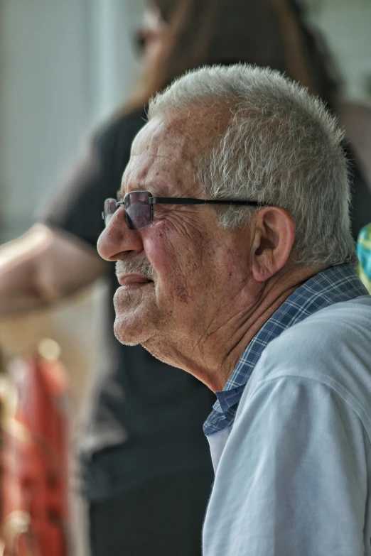 a older man with glasses smiling at the camera