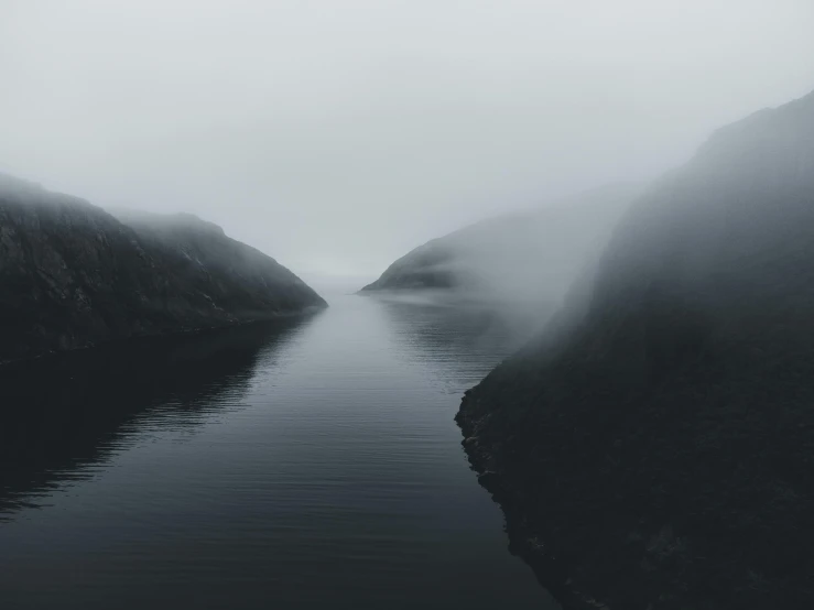 the water in the middle of a very dark area with many hills