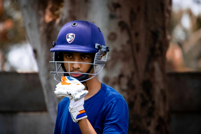 a boy wearing a helmet and holding a glove