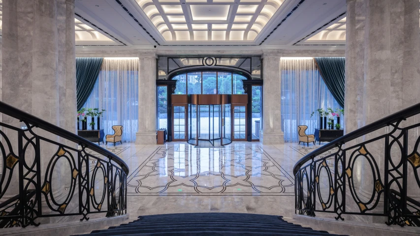 an elegant entrance hall with marble and wrought - iron handrails