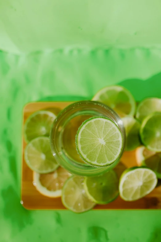 a clear vase that has some limes in it