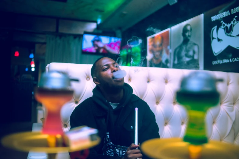 a man with an umbrella sitting down in a booth