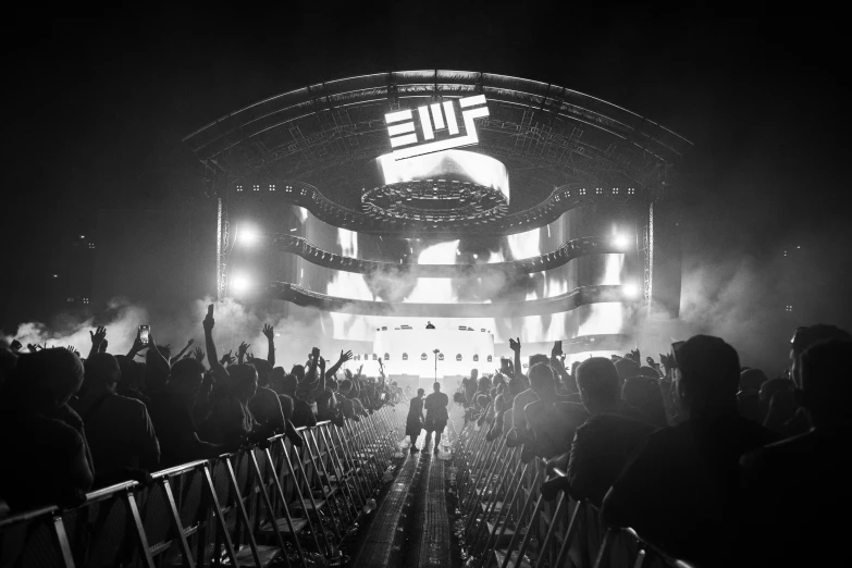 people standing and sitting on the bleachers watching a concert